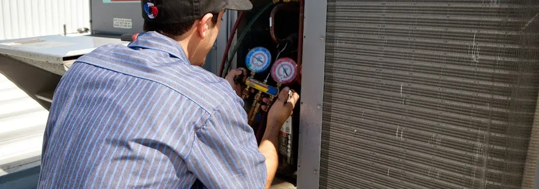 HVAC technician servicing a condenser unit in Selinsgrove